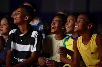 Image of the Turbocharging neighbourhoods project showing Brazilian children laughing as they watch a film